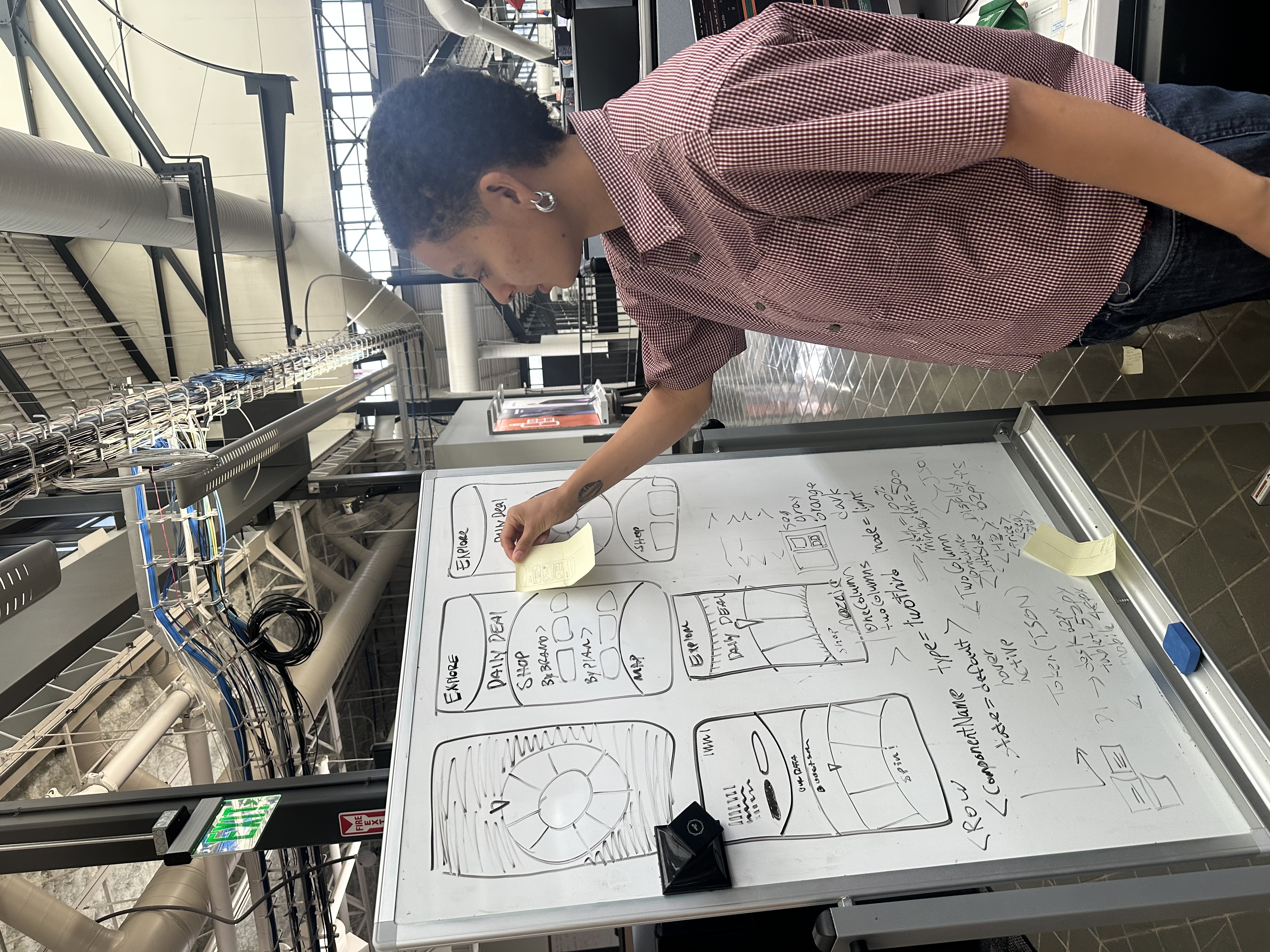Ellis arranging interface sketches on a whiteboard